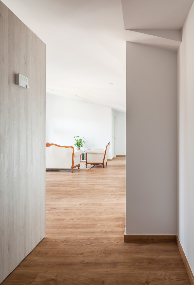 Diseño de sala de estar abierta nórdica de tamaño medio sin chimenea y televisor con suelo de madera en tonos medios, paredes blancas y suelo marrón