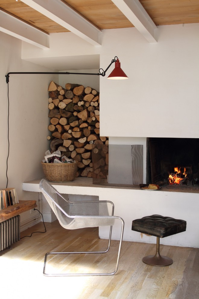Exemple d'une petite salle de séjour méditerranéenne ouverte avec un mur blanc, parquet clair, une cheminée standard et aucun téléviseur.