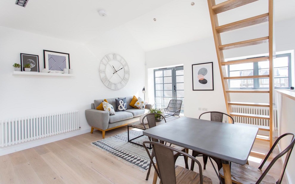 Diseño de sala de estar abierta escandinava de tamaño medio sin chimenea con paredes blancas y suelo de madera clara