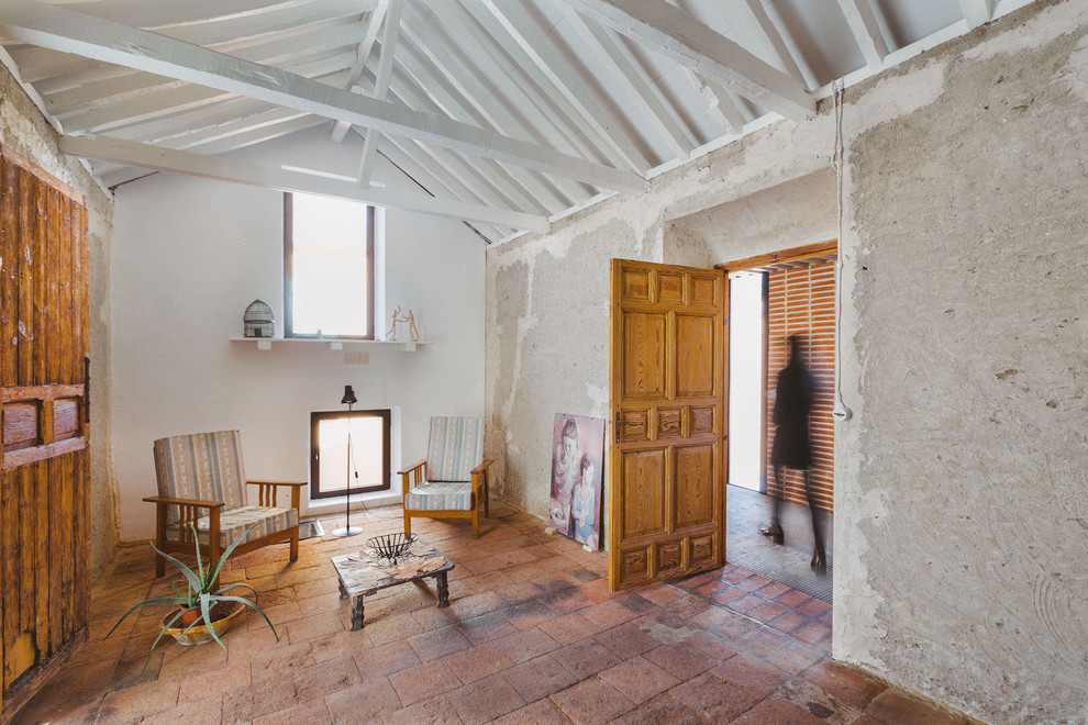 Esempio di un soggiorno classico stile loft con pareti grigie, pavimento in terracotta, nessun camino e pavimento rosso