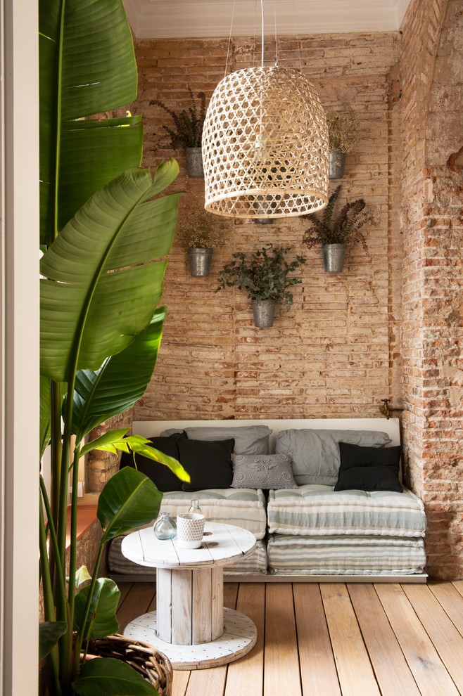 Imagen de sala de estar abierta romántica pequeña sin chimenea y televisor con paredes marrones y suelo de madera en tonos medios