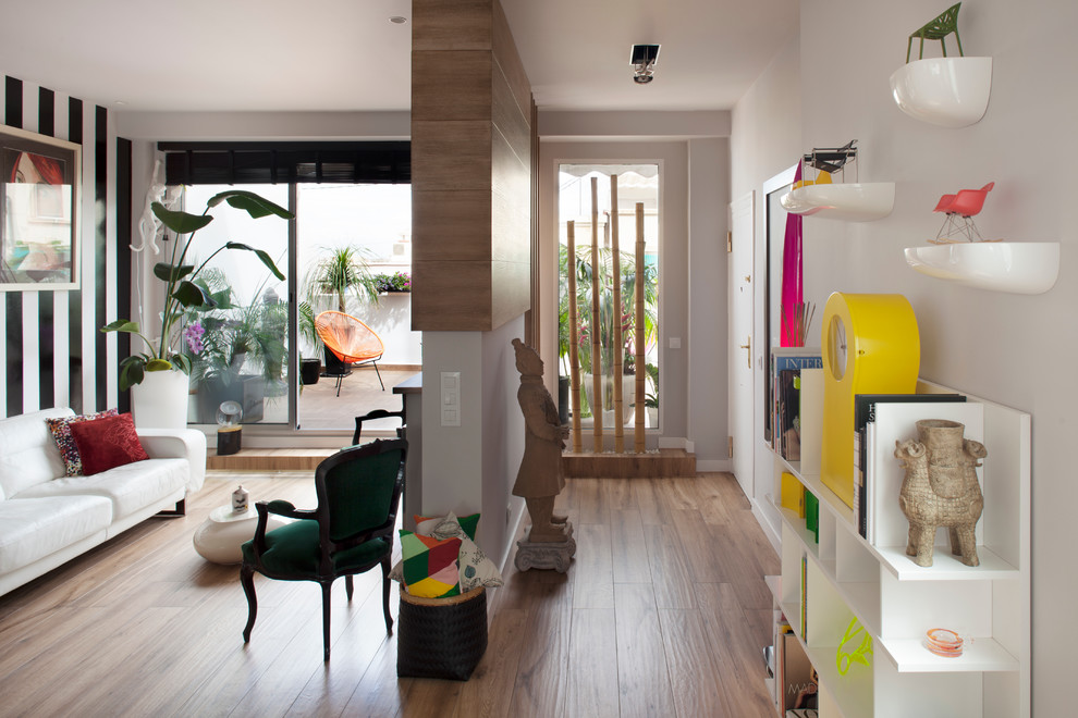 Cette image montre une salle de séjour design ouverte et de taille moyenne avec un téléviseur indépendant, une salle de musique, un mur multicolore et un sol en bois brun.