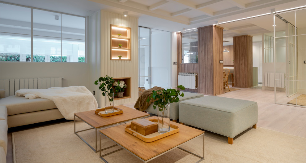 Diseño de sala de estar con biblioteca abierta escandinava grande sin chimenea con paredes blancas, suelo laminado, pared multimedia y suelo marrón