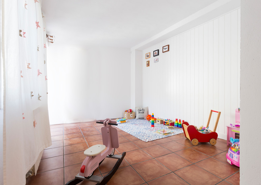На фото: изолированная комната для игр среднего размера в скандинавском стиле с белыми стенами, полом из керамической плитки и коричневым полом без камина, телевизора с