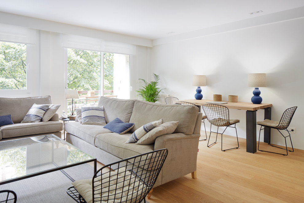 Imagen de sala de estar abierta industrial grande sin chimenea con paredes blancas, suelo de madera en tonos medios y suelo marrón
