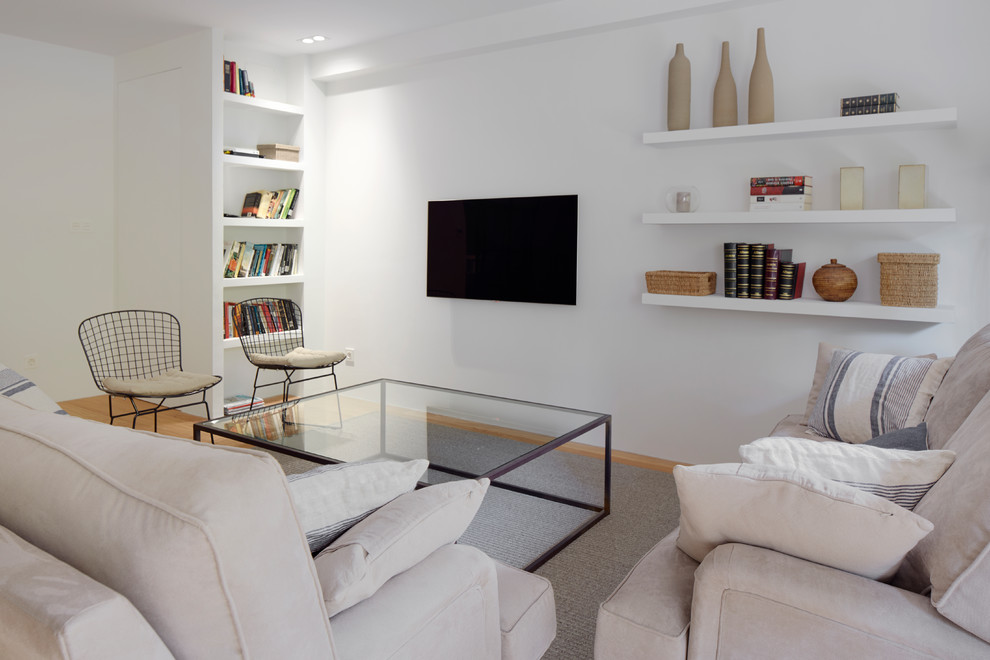 Diseño de sala de estar con biblioteca abierta industrial grande sin chimenea con paredes blancas, suelo de madera en tonos medios, televisor colgado en la pared y suelo marrón