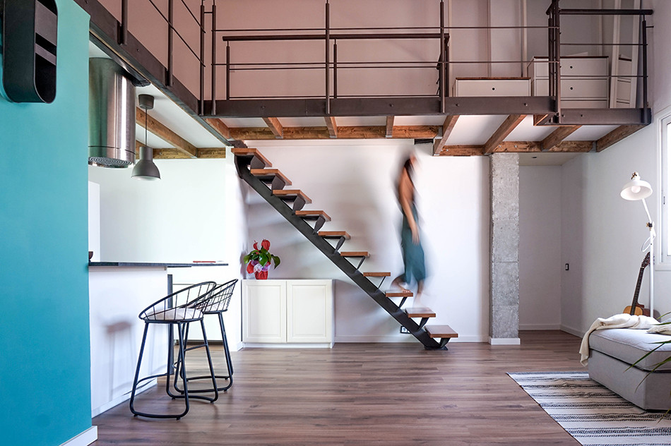 Mittelgroßes Industrial Wohnzimmer ohne Kamin, im Loft-Stil mit weißer Wandfarbe, Laminat, Eck-TV und braunem Boden in Barcelona