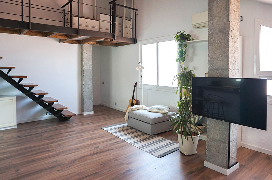 Mittelgroßes Industrial Wohnzimmer ohne Kamin, im Loft-Stil mit weißer Wandfarbe, Laminat, Eck-TV und braunem Boden in Barcelona