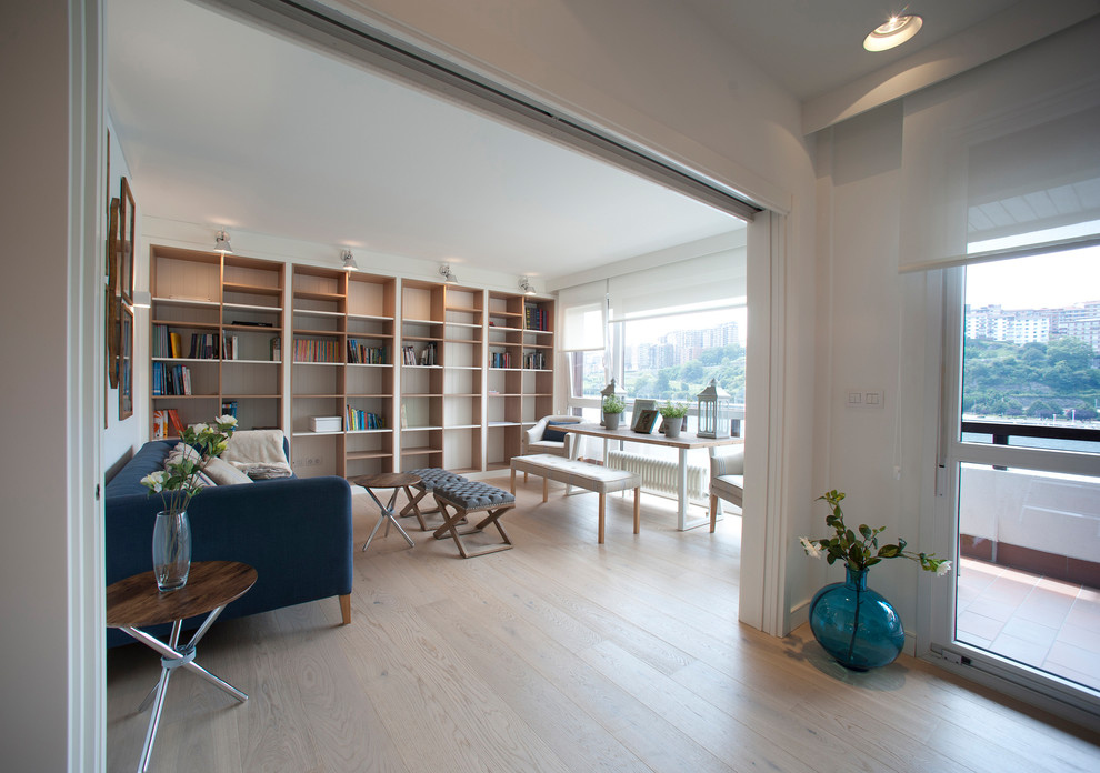 Imagen de sala de estar abierta marinera grande con paredes beige, suelo laminado, pared multimedia y suelo marrón