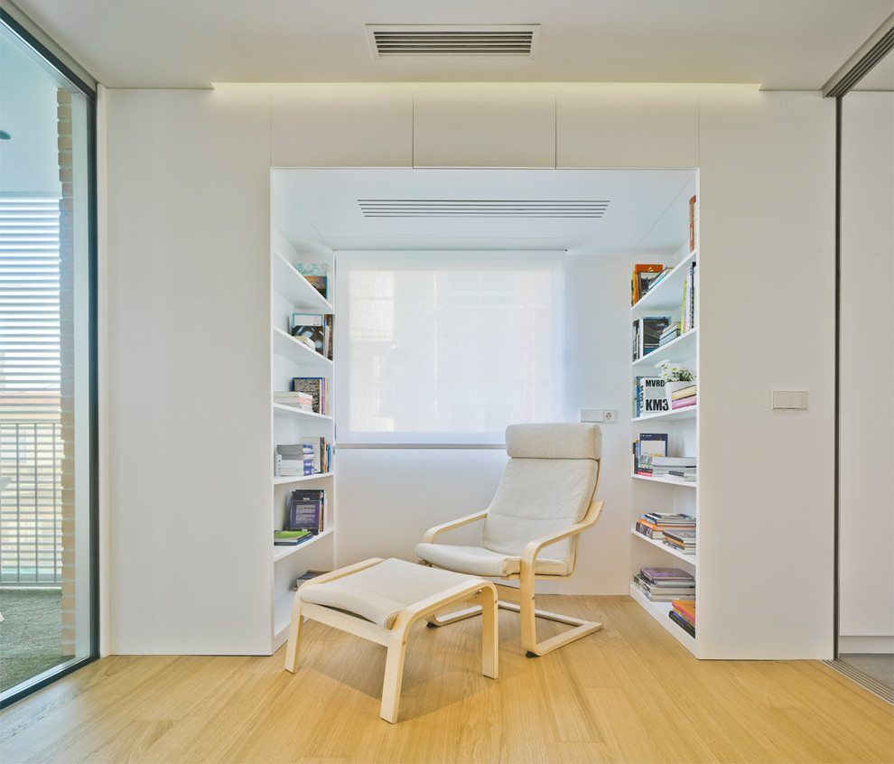 Ejemplo de sala de estar con biblioteca abierta contemporánea pequeña sin chimenea y televisor con paredes blancas y suelo de madera en tonos medios