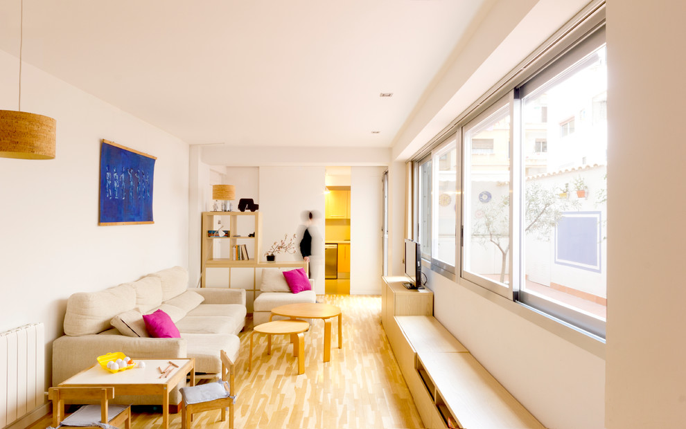 Идея дизайна: изолированная гостиная комната в современном стиле с белыми стенами, светлым паркетным полом и отдельно стоящим телевизором
