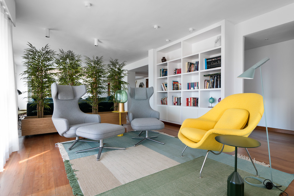 Modelo de sala de estar con biblioteca abierta nórdica grande con paredes blancas, suelo de madera oscura, suelo marrón, chimenea lineal y televisor independiente