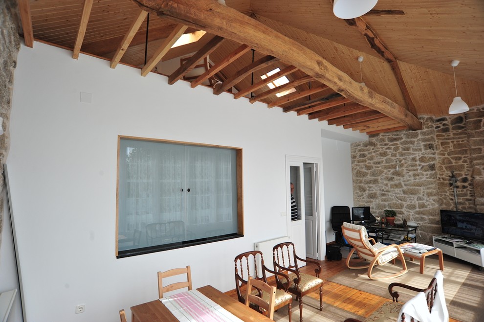 Diseño de sala de estar abierta rústica de tamaño medio con paredes blancas, suelo de madera en tonos medios y televisor independiente