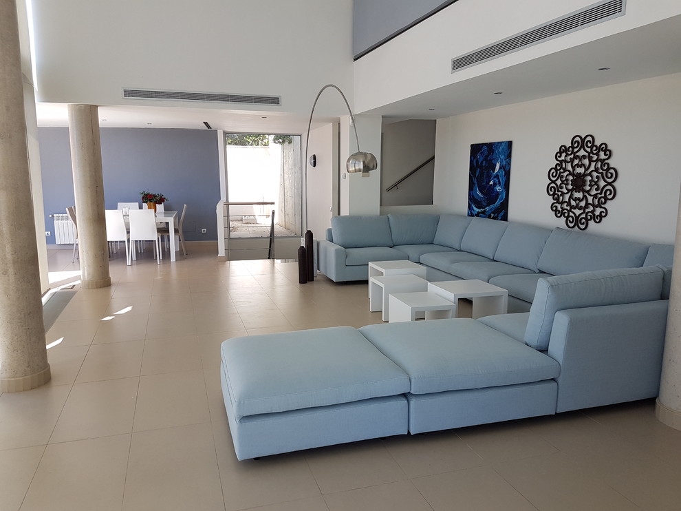 Идея дизайна: большая открытая гостиная комната в стиле модернизм с синими стенами, полом из керамогранита и бежевым полом