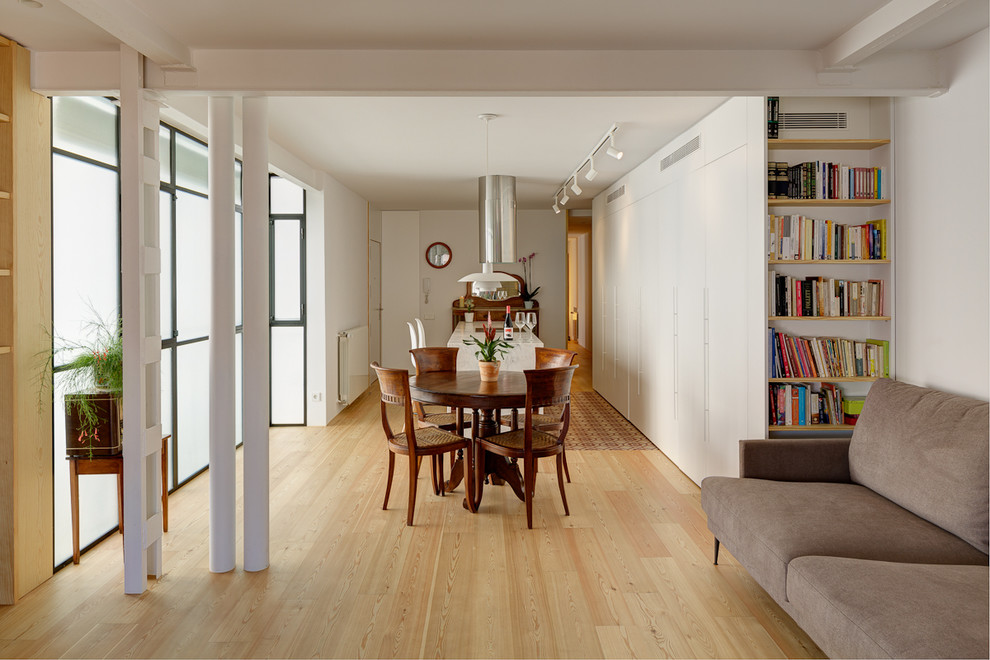 Imagen de sala de estar con biblioteca abierta contemporánea con paredes blancas y suelo de madera clara