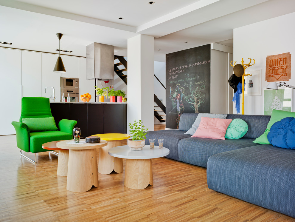 Mittelgroßes, Fernseherloses, Offenes Modernes Wohnzimmer ohne Kamin mit weißer Wandfarbe und hellem Holzboden in Sonstige