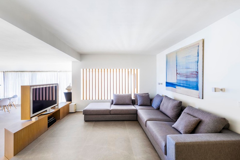 Foto de sala de estar abierta actual grande sin chimenea con paredes blancas, suelo de baldosas de cerámica y pared multimedia