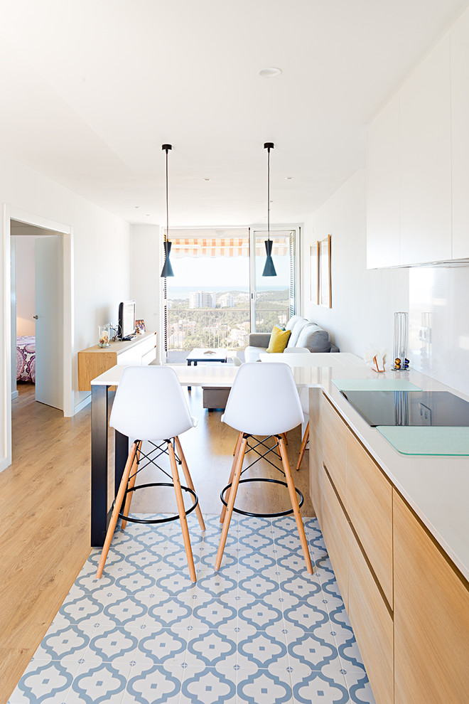 Kleines, Offenes Mediterranes Wohnzimmer ohne Kamin mit weißer Wandfarbe, hellem Holzboden, freistehendem TV und braunem Boden in Barcelona