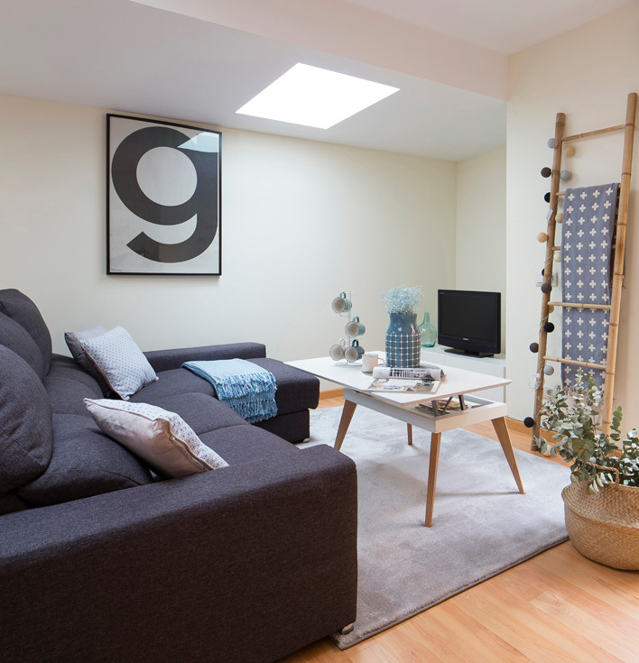 Diseño de sala de estar cerrada nórdica pequeña sin chimenea con suelo de madera en tonos medios, pared multimedia y paredes blancas