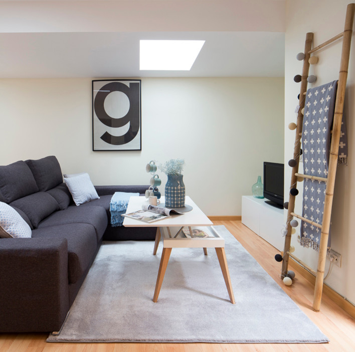 Modelo de sala de estar cerrada nórdica pequeña sin chimenea con paredes amarillas, suelo de madera en tonos medios y televisor independiente