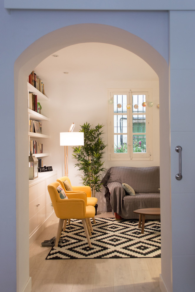 Esempio di un soggiorno nordico di medie dimensioni e aperto con libreria, pareti bianche, parquet chiaro, nessun camino, parete attrezzata e pavimento beige