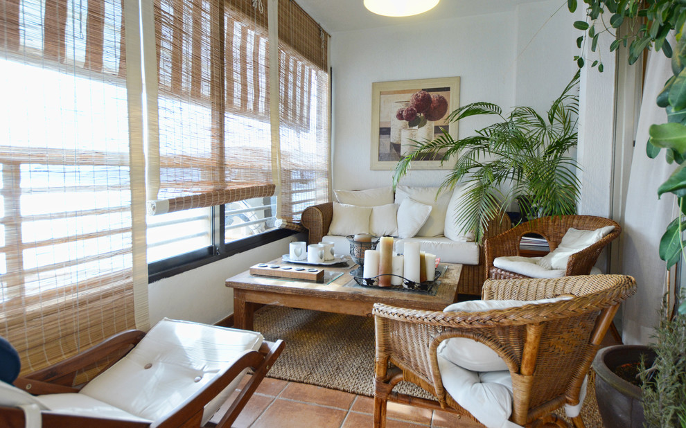 Foto de sala de estar costera de tamaño medio sin chimenea y televisor con paredes blancas y suelo de baldosas de cerámica