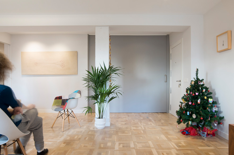 Immagine di un soggiorno design di medie dimensioni e aperto con pareti bianche, parquet chiaro e nessuna TV