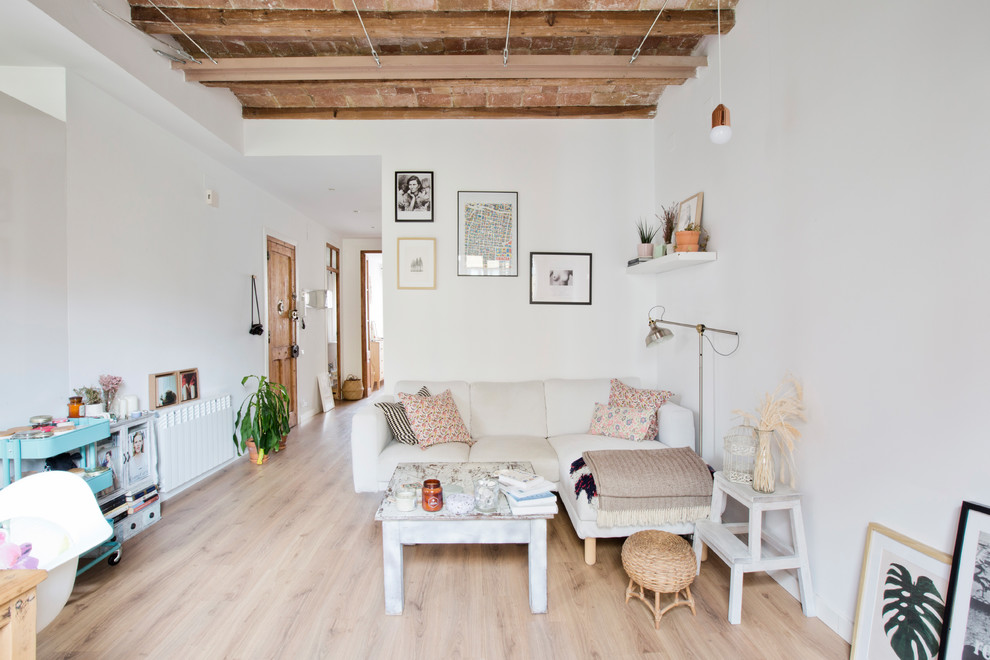 Ejemplo de sala de estar abierta escandinava pequeña sin chimenea con paredes blancas, suelo de madera en tonos medios y suelo beige