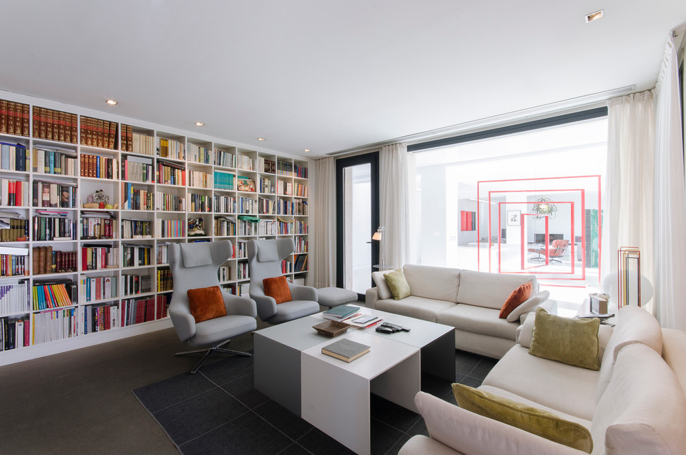 Foto de sala de estar con biblioteca contemporánea de tamaño medio sin televisor y chimenea con paredes blancas y suelo de cemento