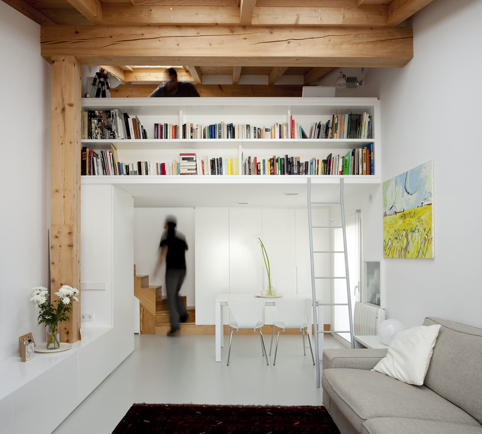 Idee per un piccolo soggiorno design chiuso con libreria, pareti bianche, pavimento in cemento, nessun camino e nessuna TV