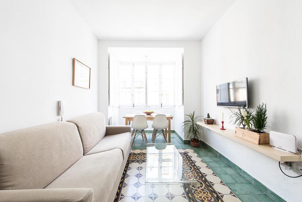 Abgetrenntes Mediterranes Wohnzimmer ohne Kamin mit weißer Wandfarbe, Keramikboden, TV-Wand und buntem Boden in Sevilla
