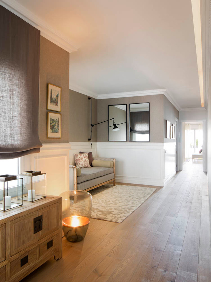 Modelo de sala de estar cerrada escandinava de tamaño medio sin chimenea y televisor con paredes beige y suelo de madera en tonos medios