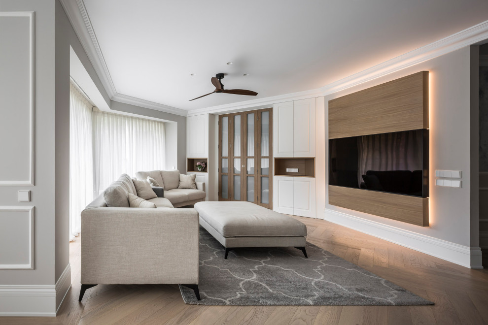 Imagen de sala de estar abierta actual extra grande con paredes grises y suelo de madera en tonos medios