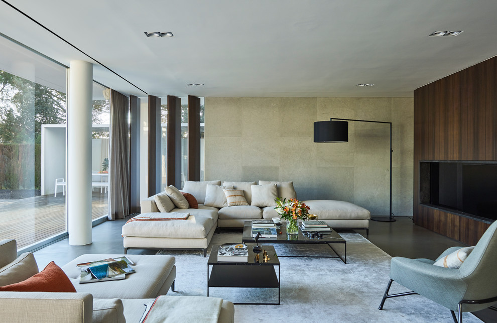 Diseño de sala de estar abierta actual con paredes grises y televisor colgado en la pared