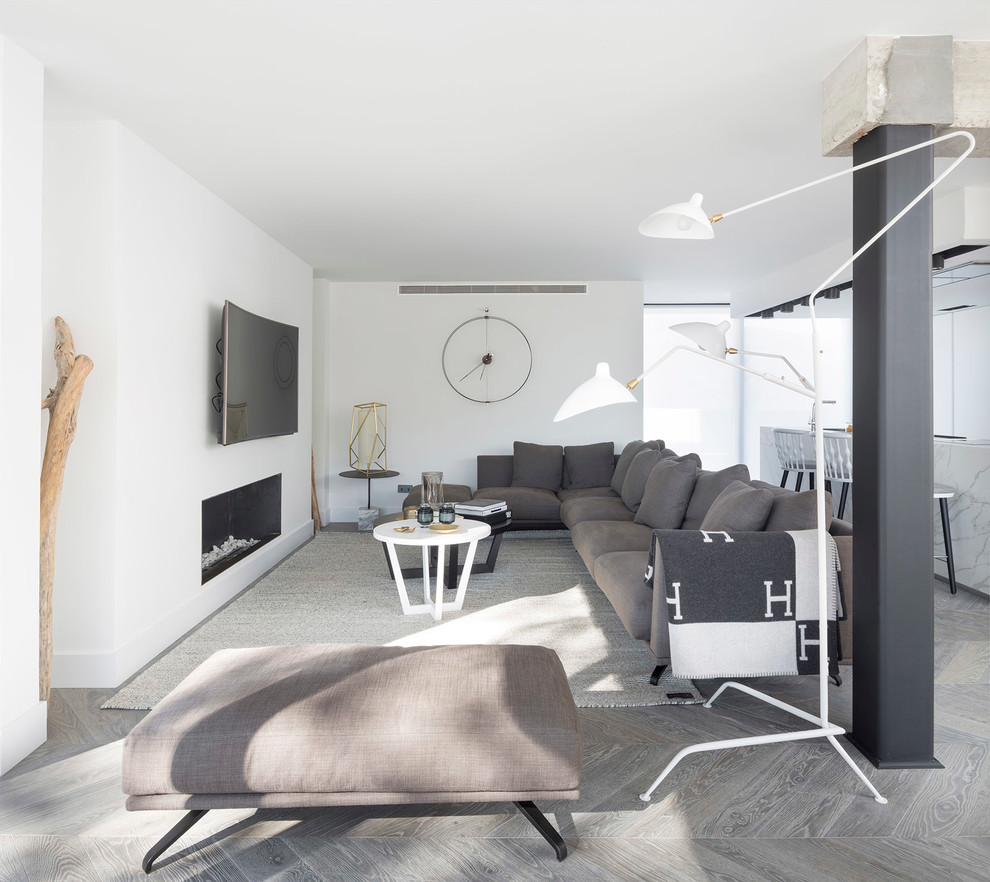 Cette photo montre une salle de séjour tendance ouverte avec un mur blanc, un sol en bois brun, une cheminée ribbon, un manteau de cheminée en plâtre et un téléviseur fixé au mur.