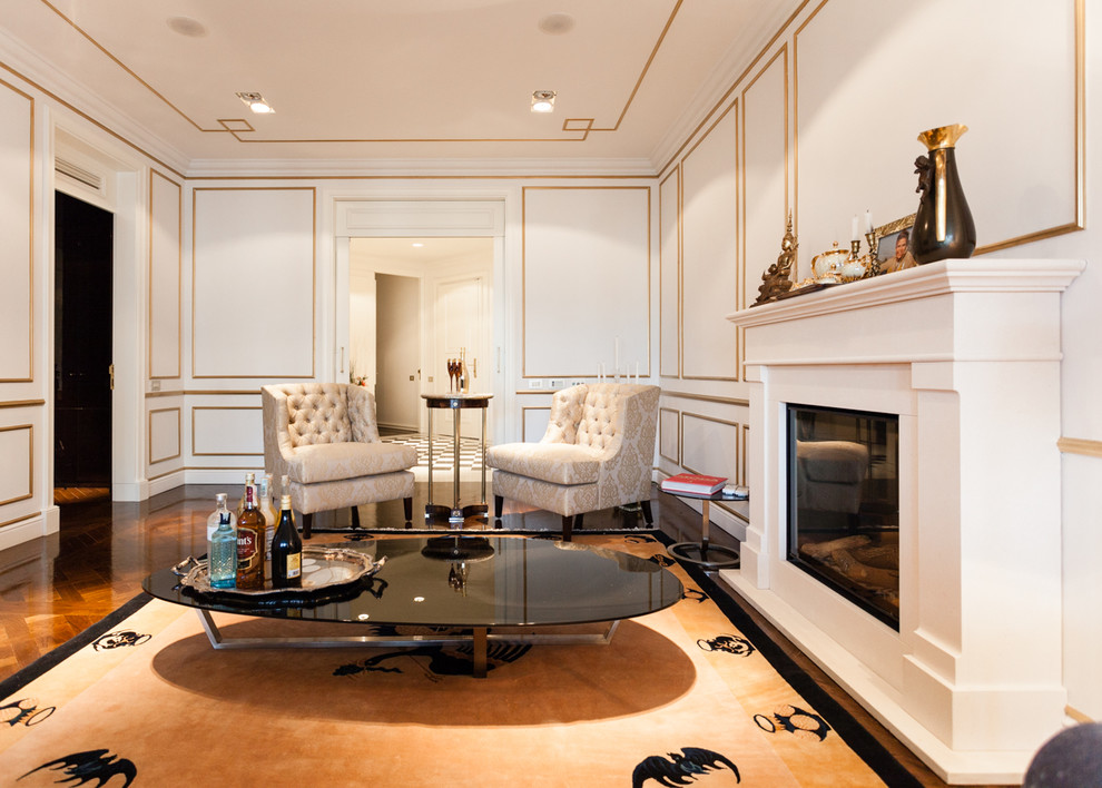 Photo of a medium sized classic enclosed living room in Barcelona with a home bar, white walls, medium hardwood flooring and a standard fireplace.