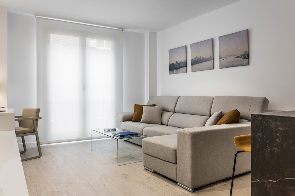 Modelo de sala de estar contemporánea de tamaño medio sin chimenea con paredes blancas, suelo de madera clara y suelo beige