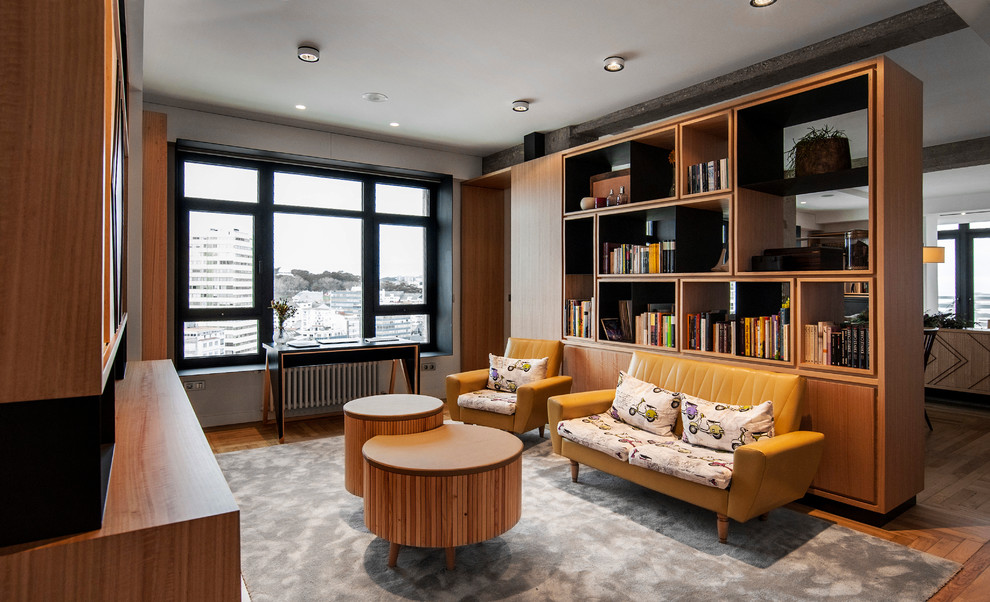 Idee per un ampio soggiorno contemporaneo stile loft con libreria, pareti bianche, pavimento in legno massello medio e nessuna TV