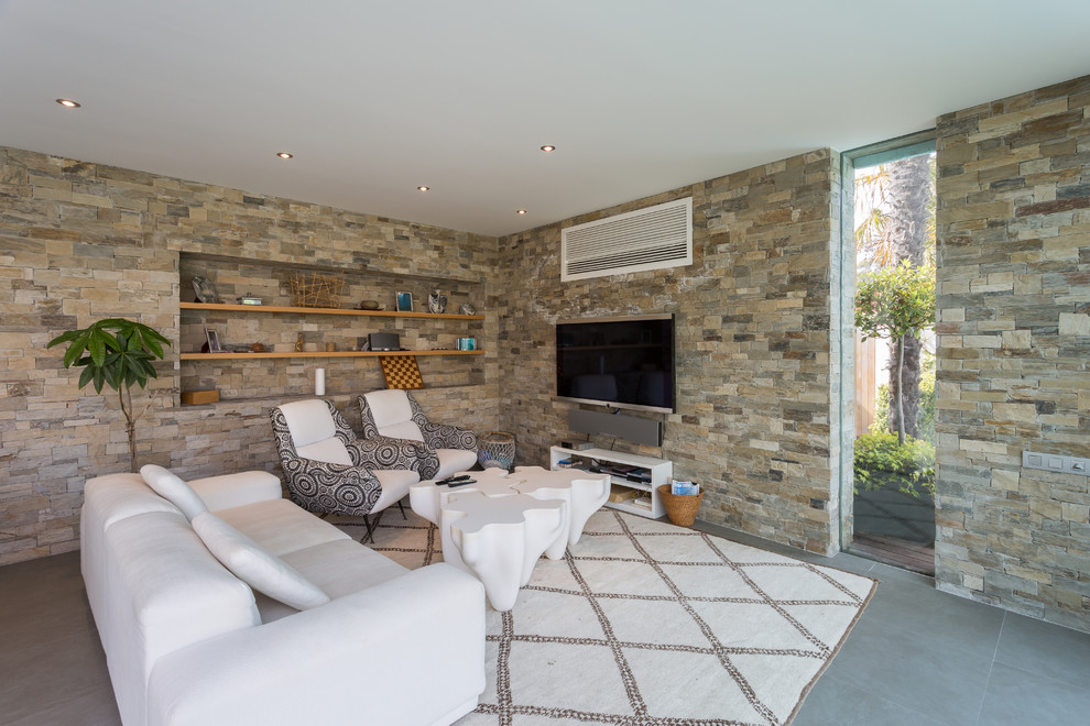 Идея дизайна: открытая гостиная комната среднего размера в современном стиле с бетонным полом и телевизором на стене без камина