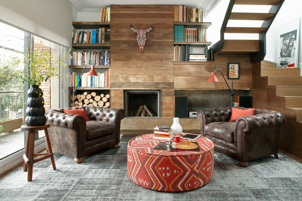 Diseño de sala de estar con biblioteca abierta contemporánea de tamaño medio sin televisor con paredes blancas, suelo de madera en tonos medios, todas las chimeneas y marco de chimenea de madera