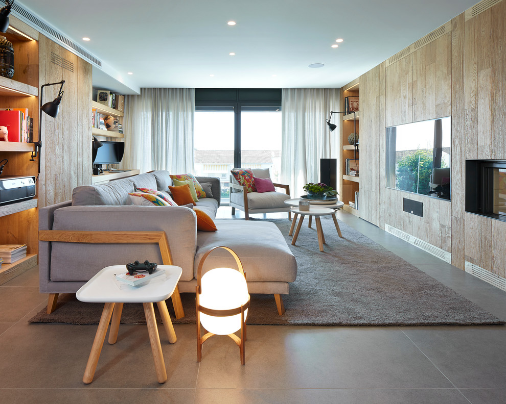 Imagen de sala de estar abierta actual con suelo de baldosas de cerámica y televisor colgado en la pared