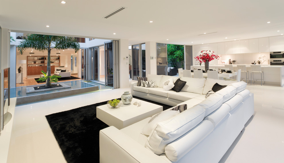 Стильный дизайн: огромная открытая гостиная комната в современном стиле с белыми стенами без камина - последний тренд