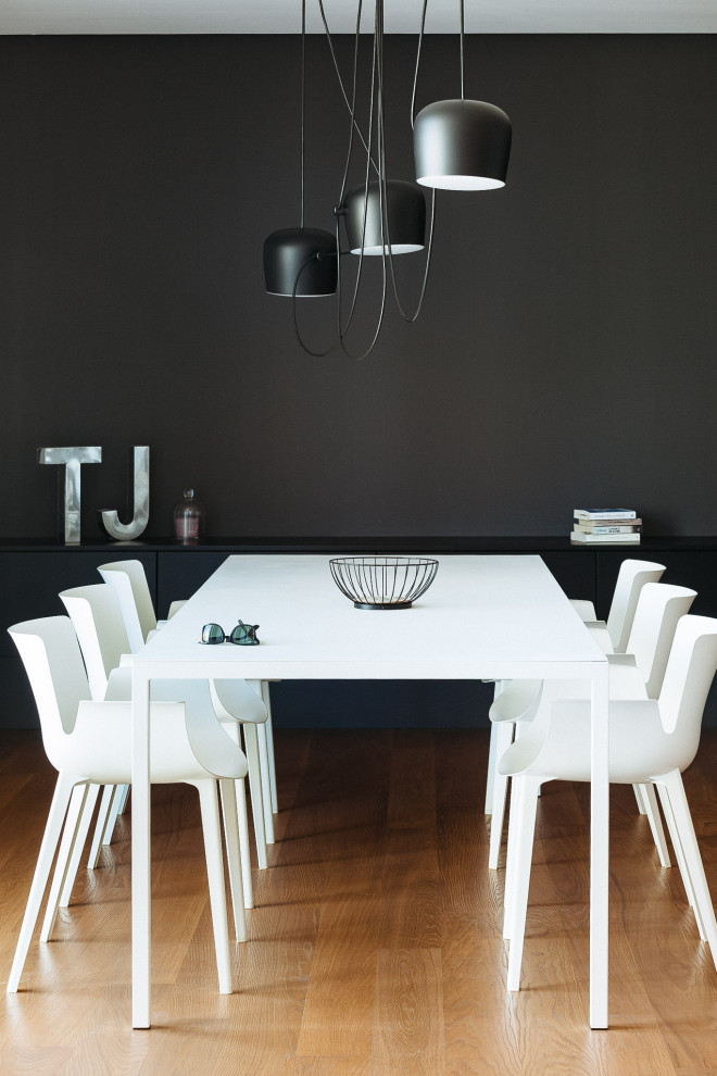 Inspiration pour une salle à manger design de taille moyenne avec un mur noir et un sol marron.