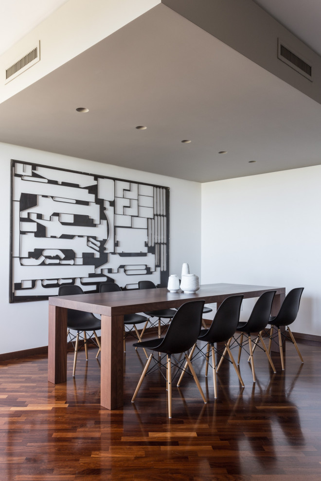 Imagen de comedor actual de tamaño medio con paredes blancas, suelo de madera en tonos medios y suelo marrón