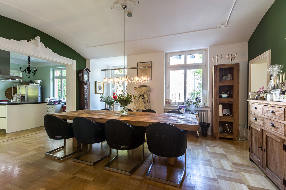 Immagine di una sala da pranzo design di medie dimensioni con pareti verdi e pavimento in legno massello medio