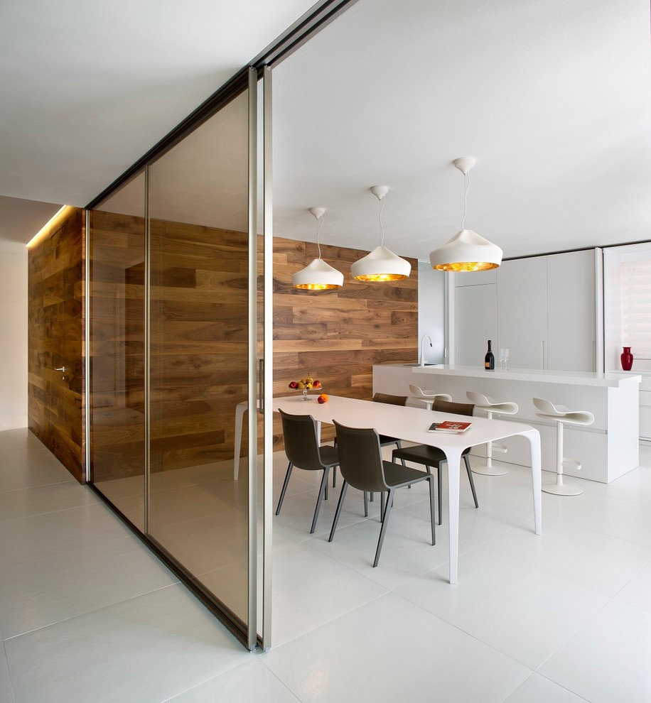 Immagine di una grande sala da pranzo aperta verso la cucina contemporanea con pareti bianche