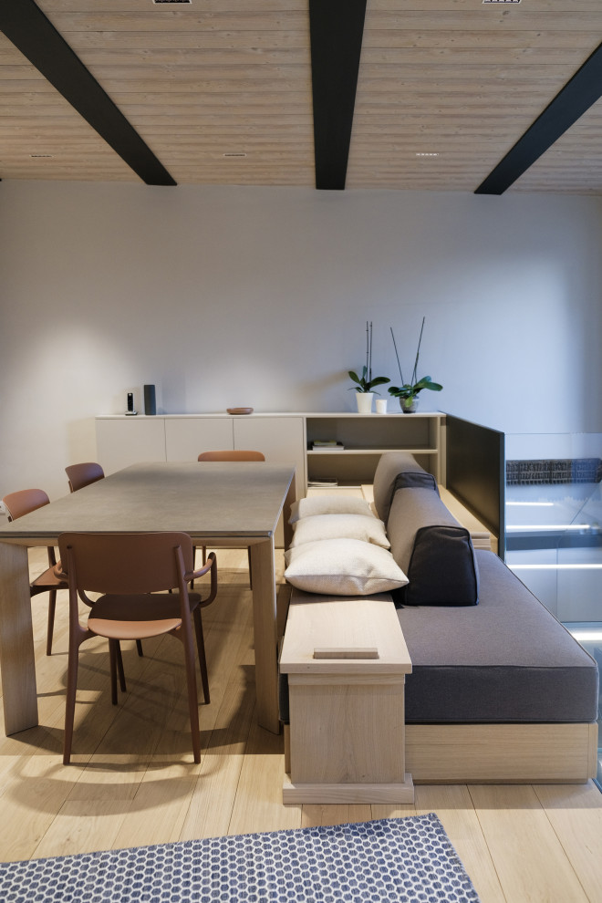 Mittelgroße Moderne Wohnküche ohne Kamin mit grauer Wandfarbe, hellem Holzboden und beigem Boden in Turin