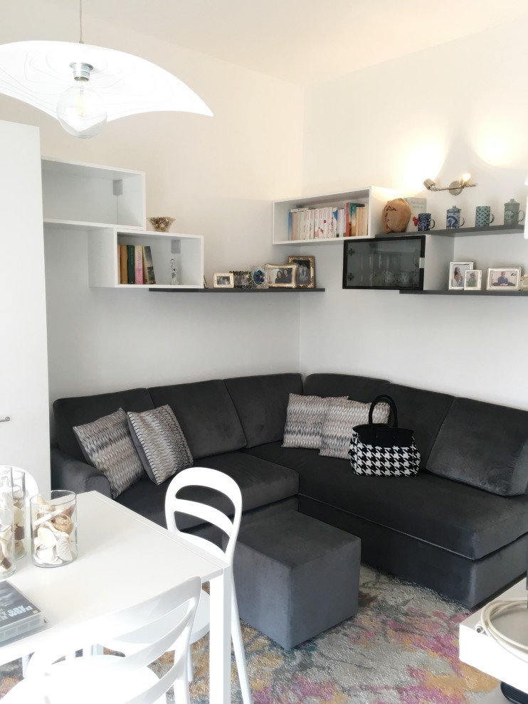 Immagine di una piccola sala da pranzo aperta verso la cucina minimal con pareti bianche, pavimento in gres porcellanato e pavimento beige