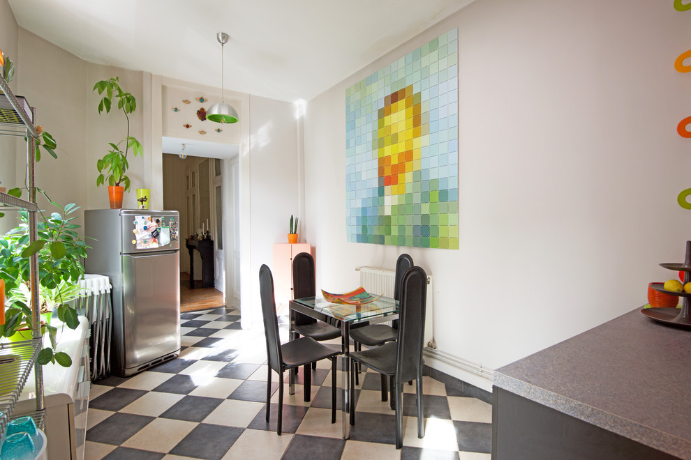 Cette image montre une salle à manger ouverte sur la cuisine design avec un mur beige et un sol multicolore.