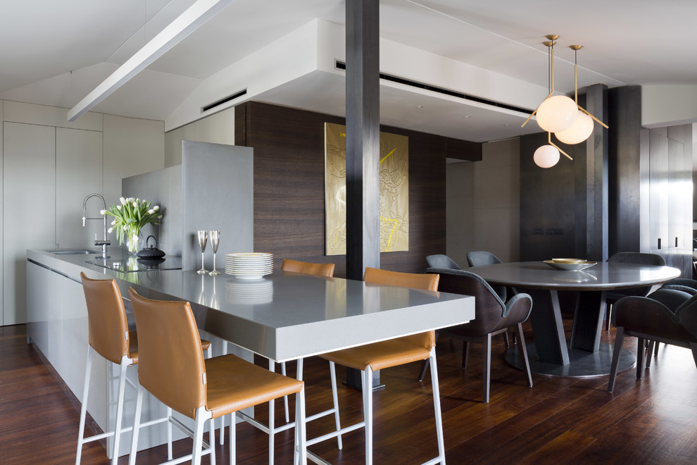 Immagine di una sala da pranzo aperta verso la cucina contemporanea con parquet scuro, pareti multicolore e pavimento marrone